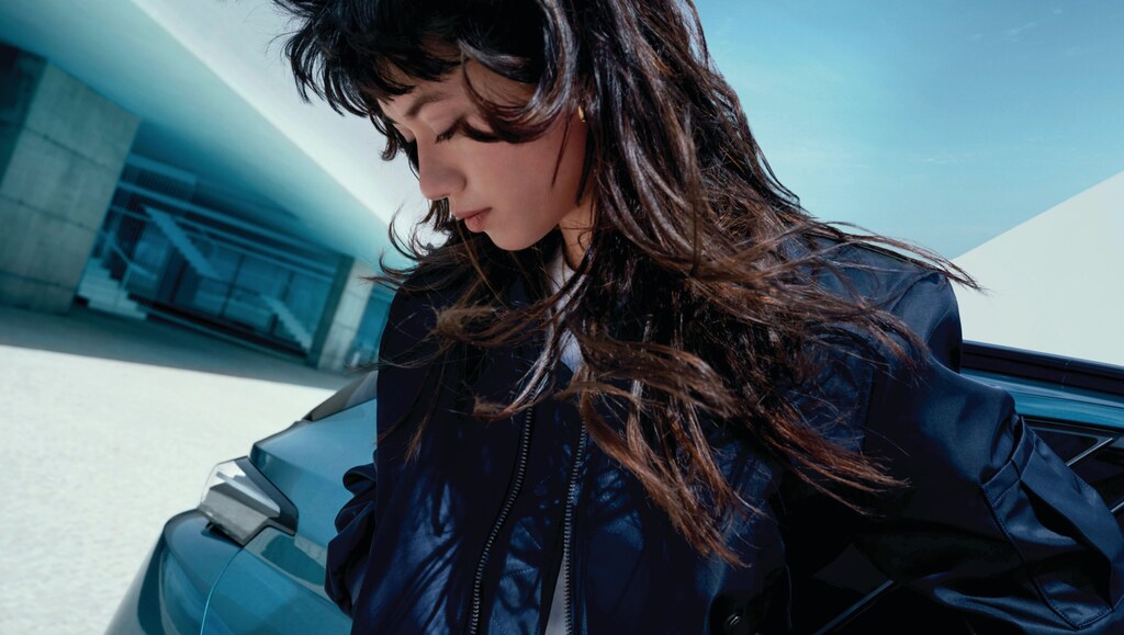 A woman standing next to a PEUGEOT Hybrid