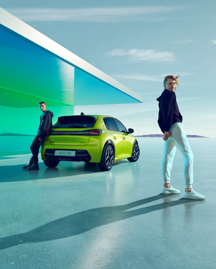 An adult couple are positioned next to a new PEUGEOT 208 Hybrid Yellow Agueda.