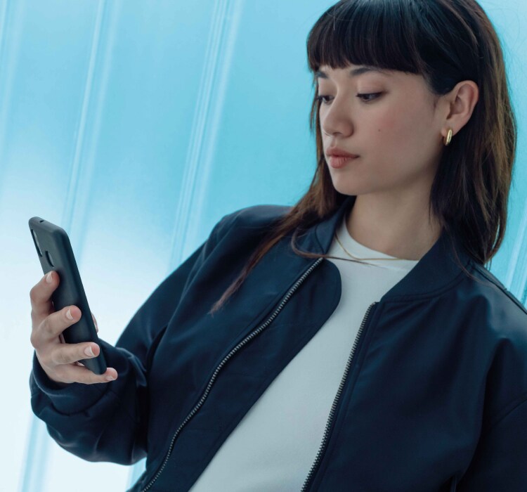 Woman with smartphone to use MyPeugeot App